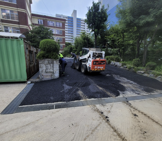 학교 진입로 아스콘 포설 작업 중